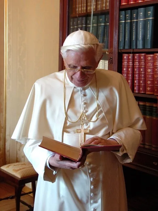 Pope Benedict XVI reading a book in his library