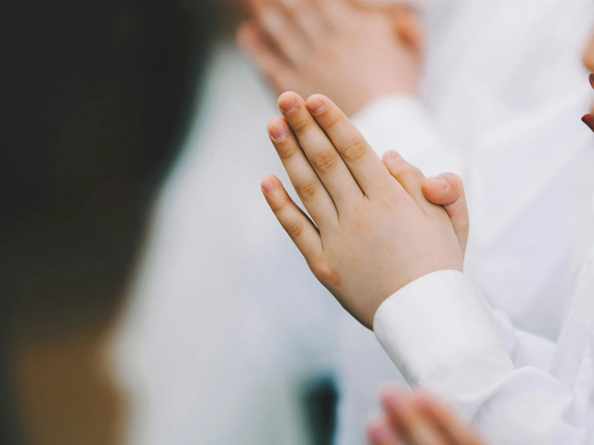A child with hands folded in prayer