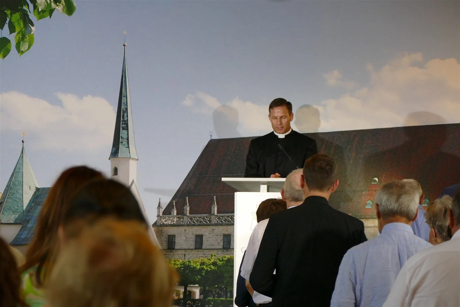 A Catholic priest speaking to an audience at a public gathering