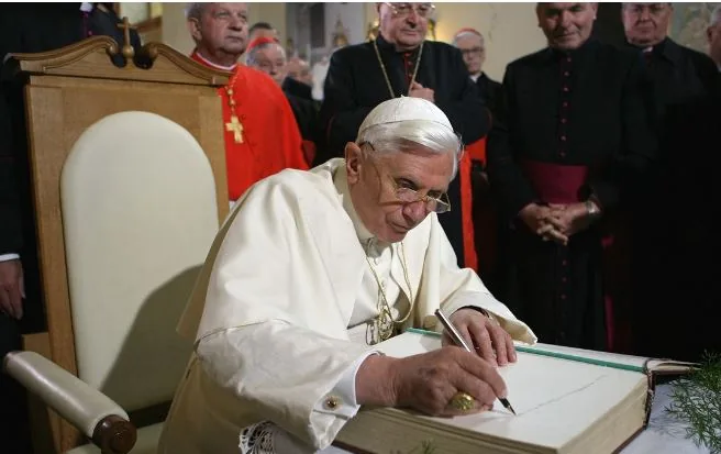 Pope Benedict XVI signing a book