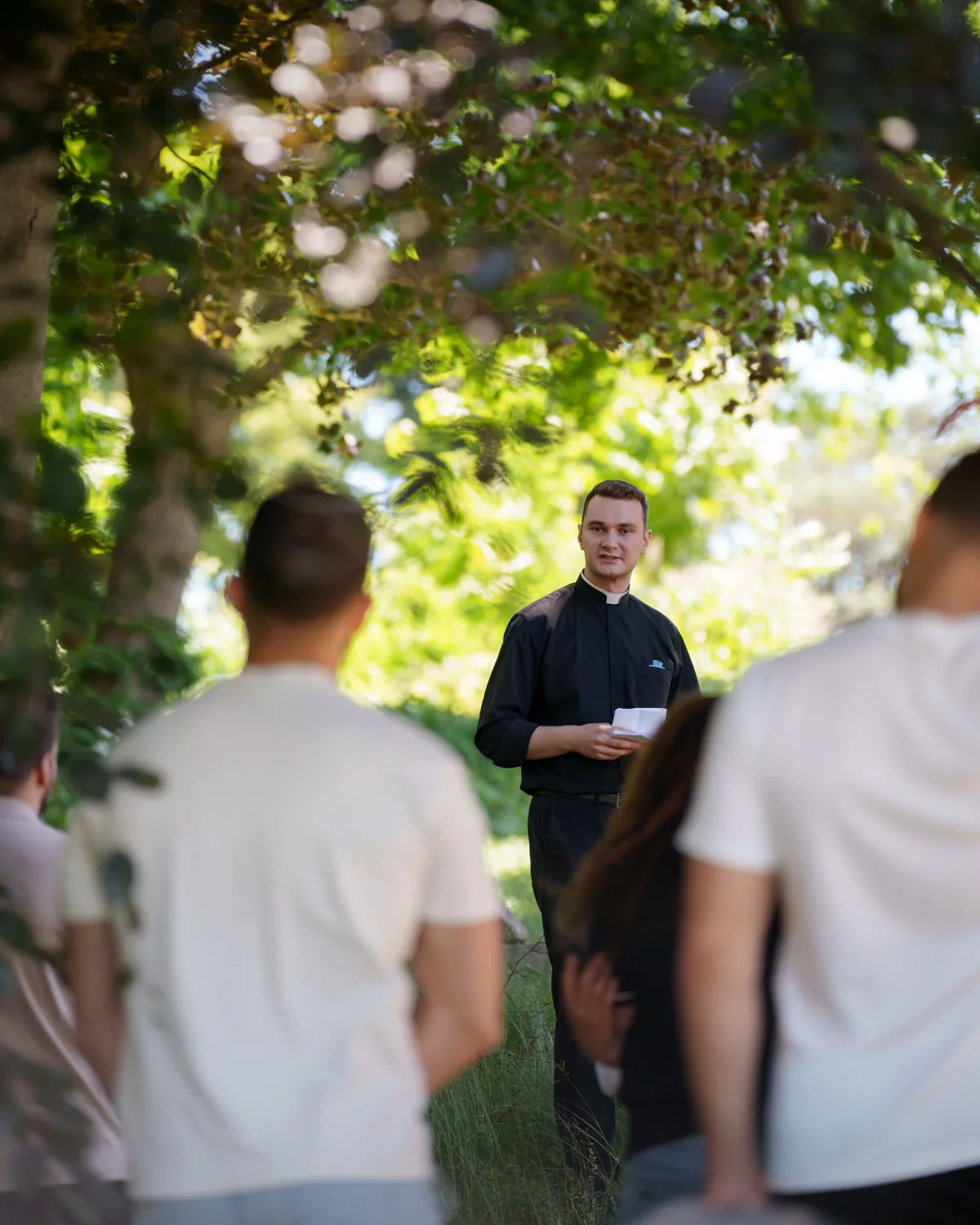 A priest leading a retreat gathering outdoors